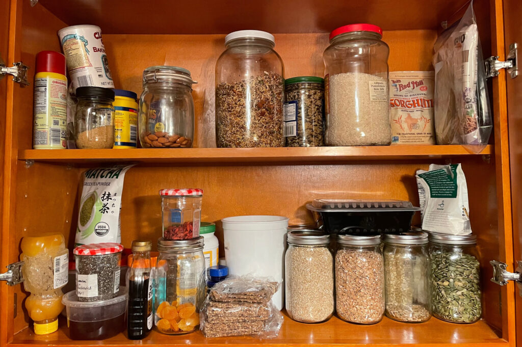 Glass jars filled with flour, grains, and beans on a shelf.
