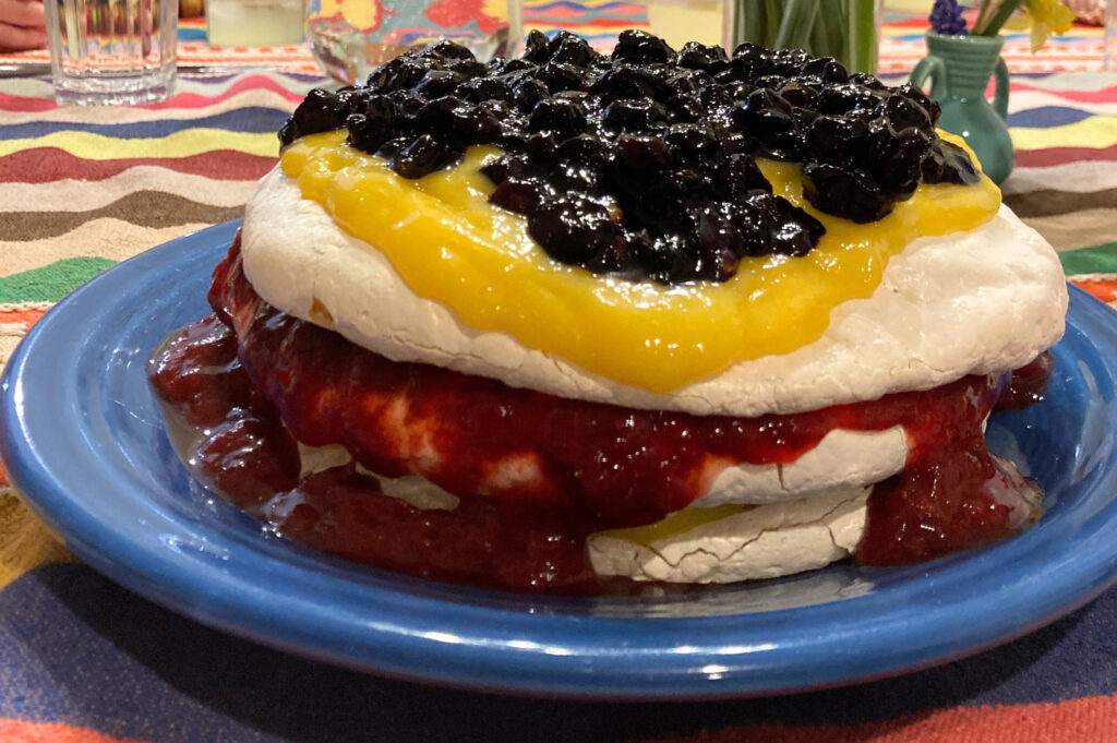 Pavlova with blueberry and strawberry jams, and lemon curd.