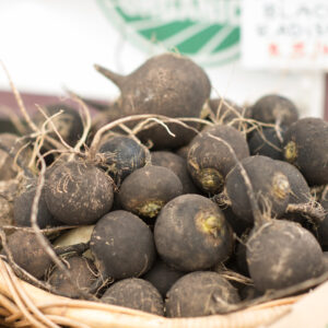 a basket filled with black radishes